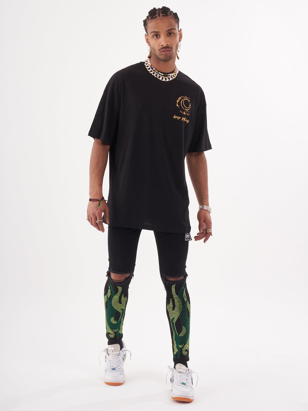 A man wearing a VINCENT T-SHIRT and green leggings.