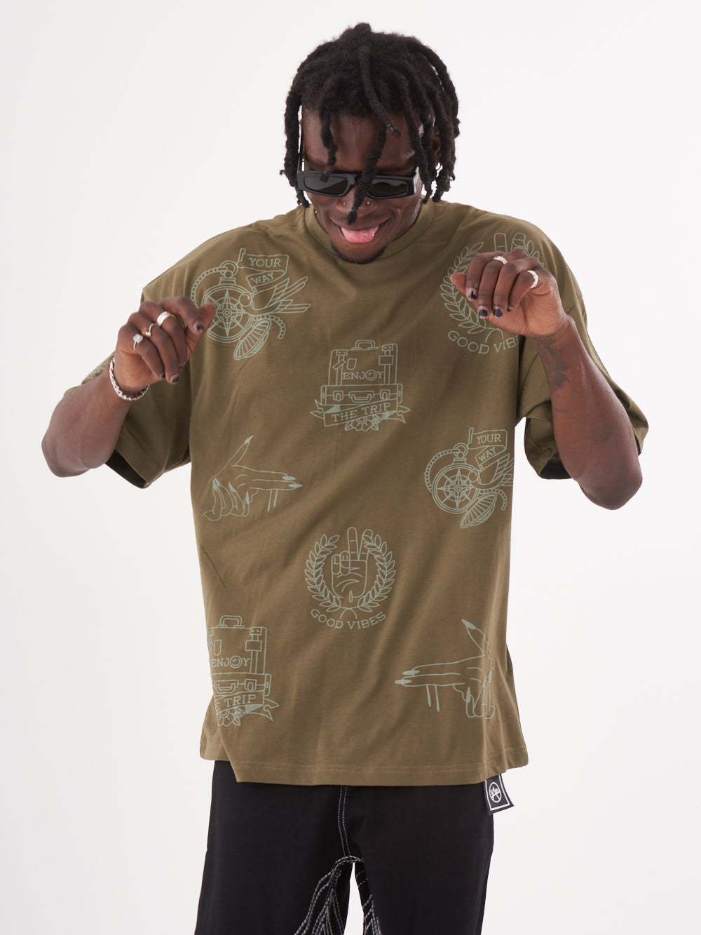 Upper-body front shot of a man wearing an olive color oversized t-shirt called VICTORY by Sernes Streetwear
