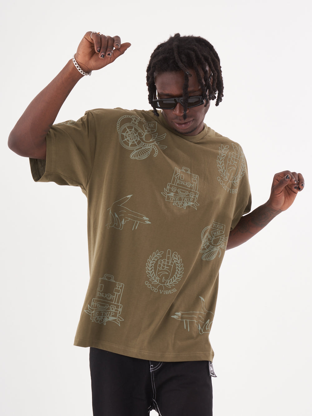 A man wearing an olive color VICTORY oversized t-shirt by Sernes Streetwear