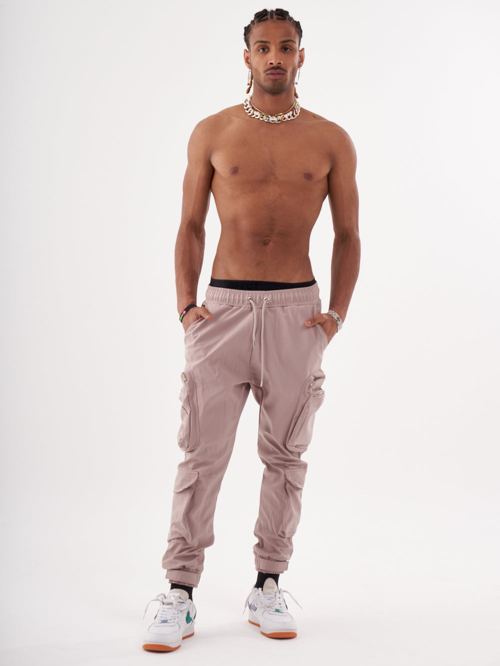 A man in SPUNK JOGGERS | MAUVE posing in front of a white background.