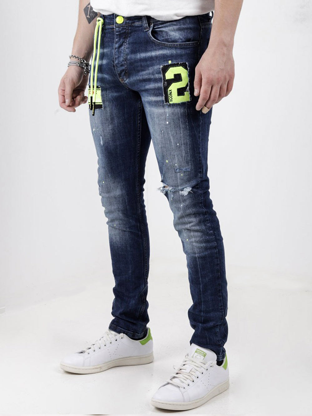 A man wearing a pair of Phosphorus jeans with a number on them.