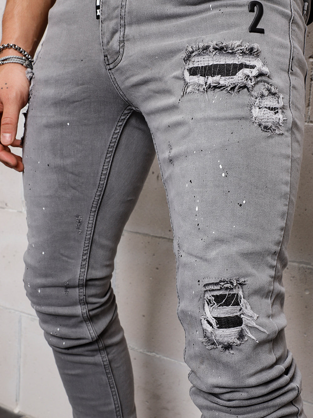 A man is wearing grey SMOKE SPLASH with holes in them.