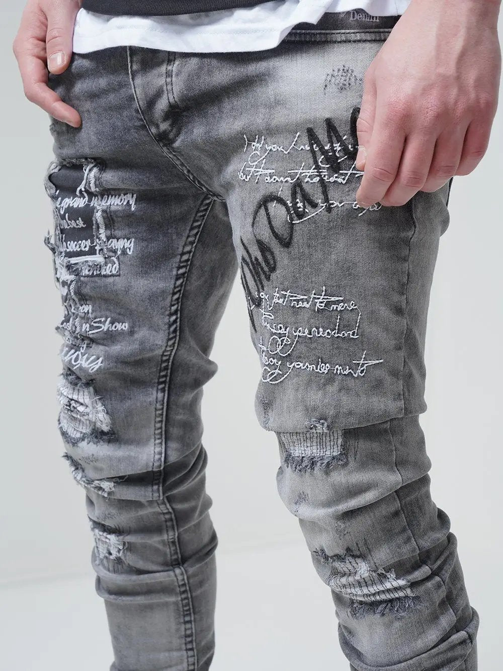 A man donning ripped skinny fit jeans in a casual t-shirt showcasing London streetwear fashion.