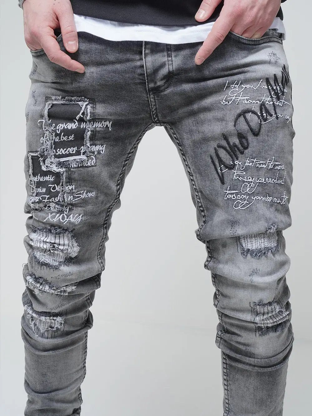 A man wearing ripped skinny fit jeans with writing on them called LONDON.
