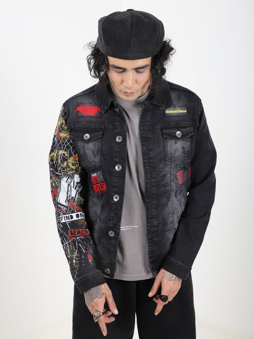 A man wearing a JETMAN denim jacket with patches on it.