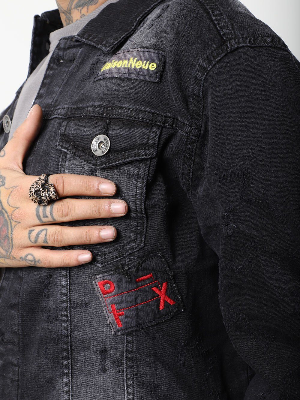 A man wearing a JETMAN denim jacket with patches on it.